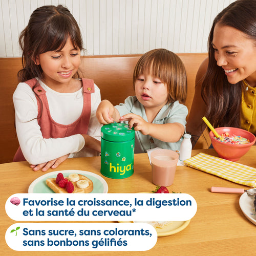Kids taking vitamin tablets from a green Hiya container at breakfast table with mom