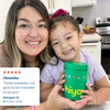 Mom and daughter smiling with green Hiya vitamin tablet container in kitchen, healthy kids nutrition