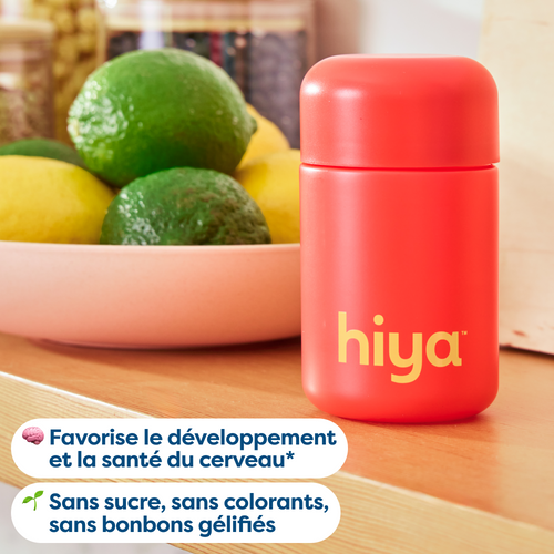 Red Hiya vitamin tablet bottle beside bowl of lemons and limes, sugar-free, no artificial colors