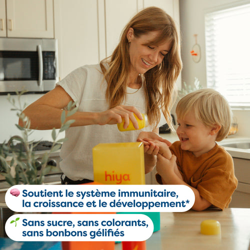 Mom giving child vitamin tablet from yellow bottle in kitchen, supports immunity and growth, sugar-free