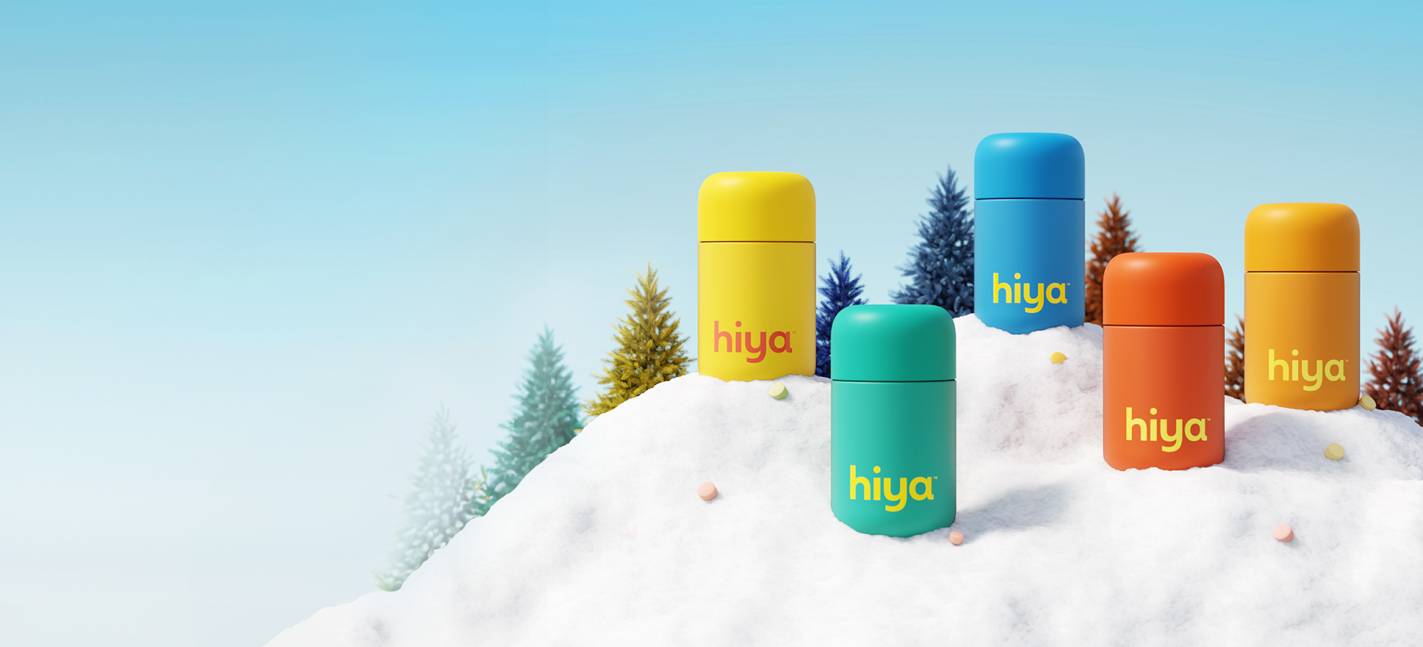 Colorful containers labeled "hiya" are arranged on a snowy surface, surrounded by stylized trees against a blue sky.