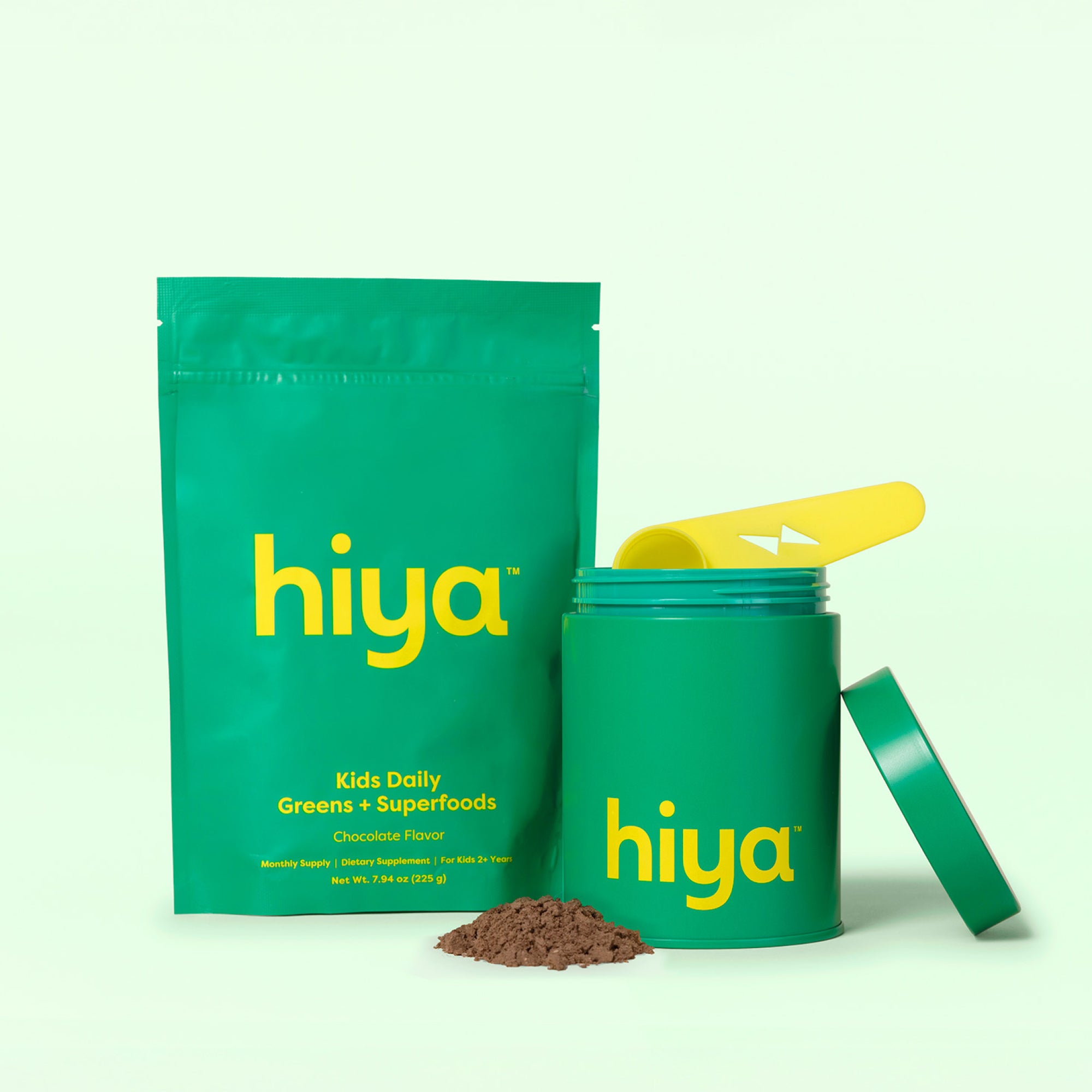 Hiya Kids Daily Greens + Superfoods chocolate flavor powder with vitamin supplement container and scoop