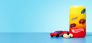 Hot Wheels themed vitamin tablets with toy car on blue background