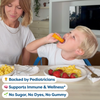 Child taking orange kids vitamin with mom, eating breakfast of eggs and strawberries, pediatrician-backed immune support