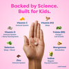 Hand holding kids' vitamin tablet with science-backed nutrients like Vitamin C, D, B12, Zinc for immune, sleep, growth
