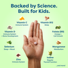 Hand holding kids' vitamin tablet with science-backed nutrients like Vitamin C, D, B12, Zinc for immune, sleep, growth