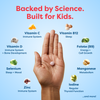 Hand holding kids' vitamin tablet with science-backed nutrients like Vitamin C, D, B12, Zinc for immune, sleep, growth