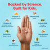 Hand holding kids' vitamin tablet with science-backed nutrients like Vitamin C, D, B12, Zinc for immune, sleep, growth